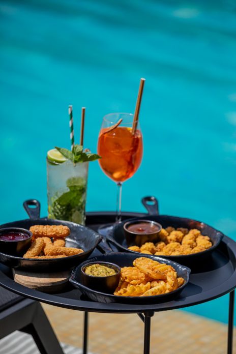Мохіто та Aperol Spritz із хрусткими закусками біля басейну готелю